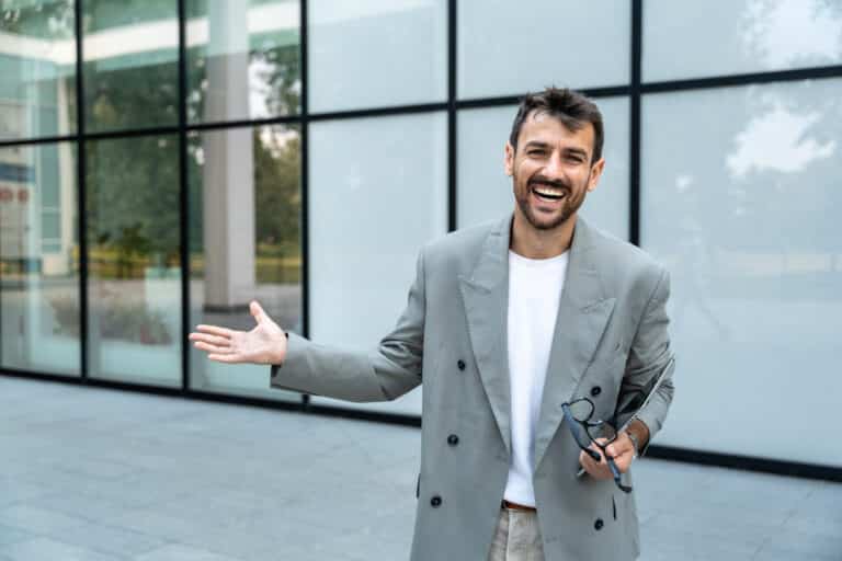 Young business coach standing in front of the office building smiling