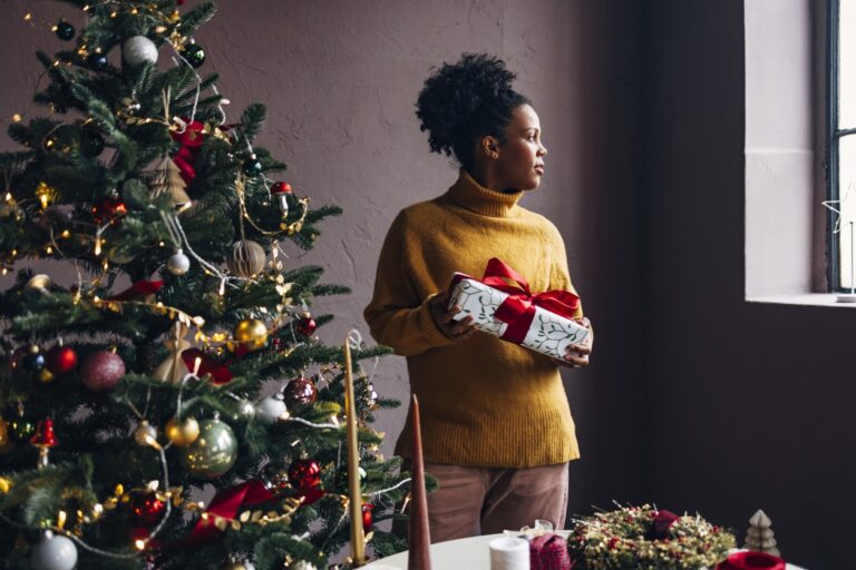 Women standing next to her Christmas tree during the Holidays