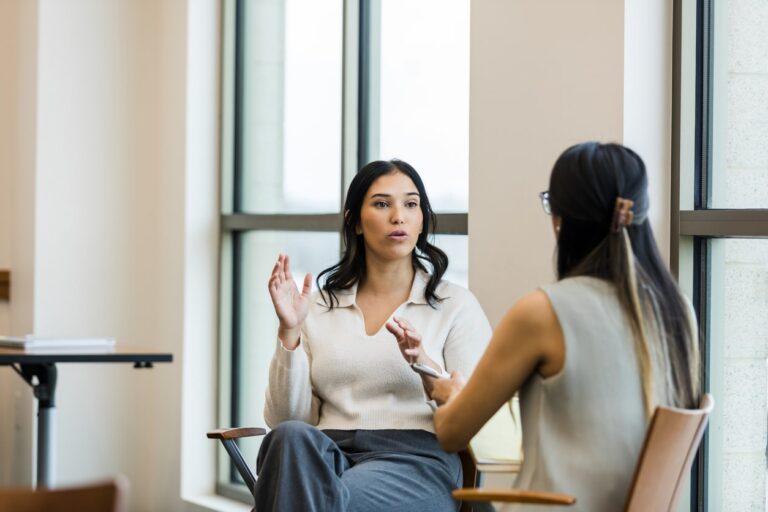 Two young people having a conversation about what bipolar disorder is, it's symptoms and signs