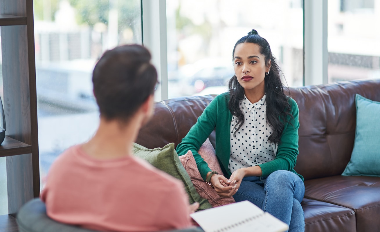 A young female is speaking to a professional and is actively listening to his feedback