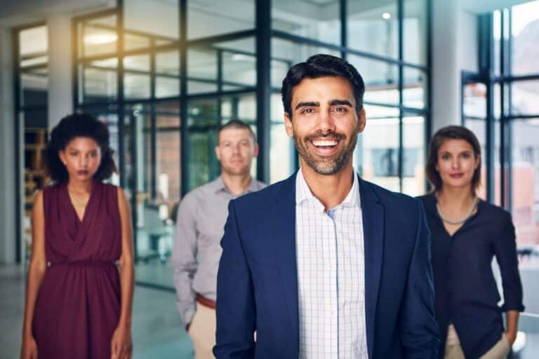 An accredited coach smiling with a team at work