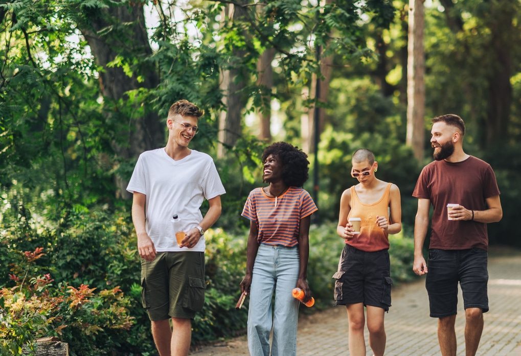 Multicultural group of introvert and extrovert friends walking and talking