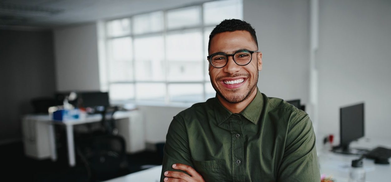 Portrait of a happy confident young businessman standing in the office