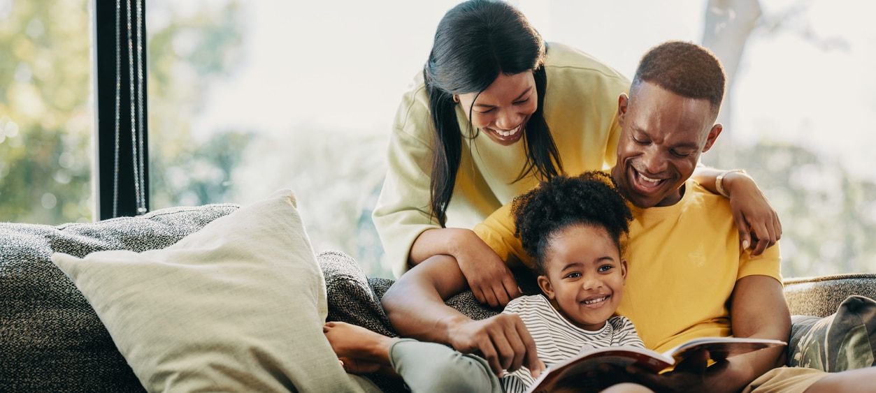 Happy girl reading with her parents