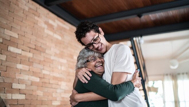 Grandmother hugs grandson at home
