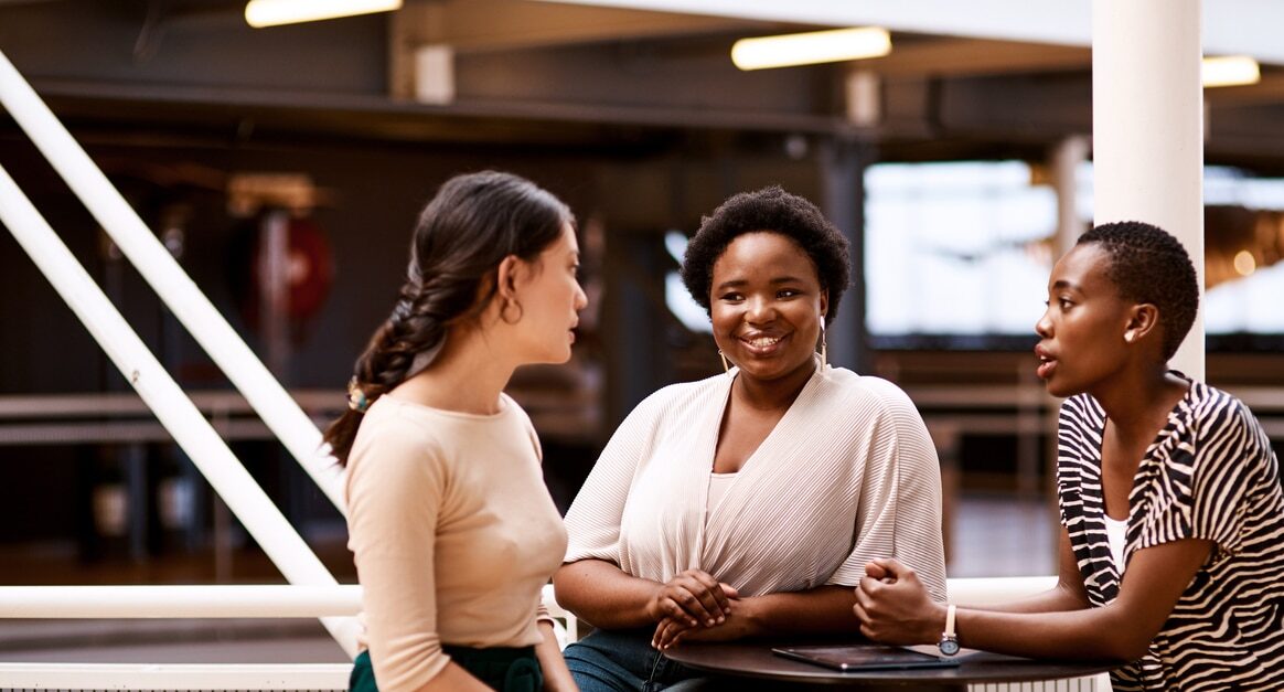 A group of business women using interpersonal communication to work on a creative project