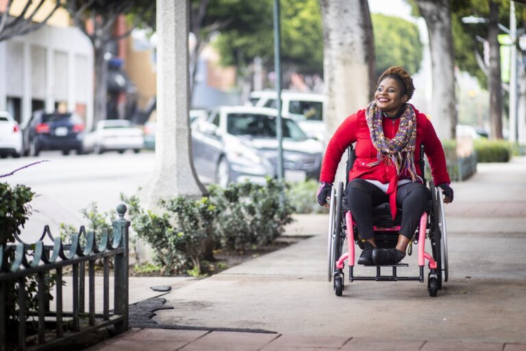 A young black disabled woman with a wheelchair in the city.