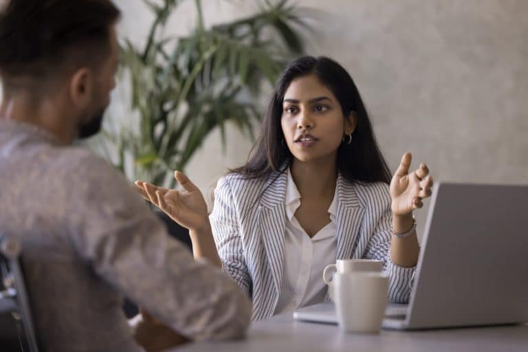 Young indian business woman discussing reconciliation with an employee
