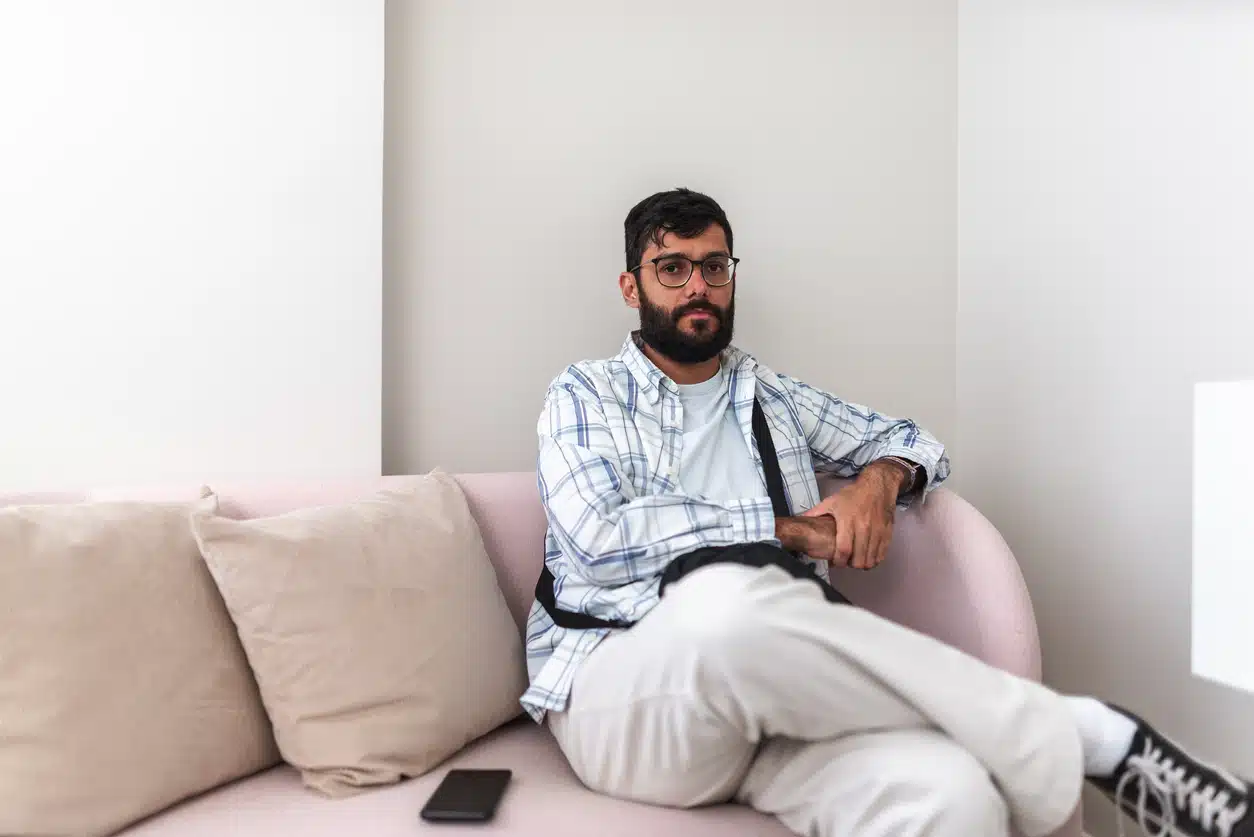 Non-binary adult with autism sitting on the couch
