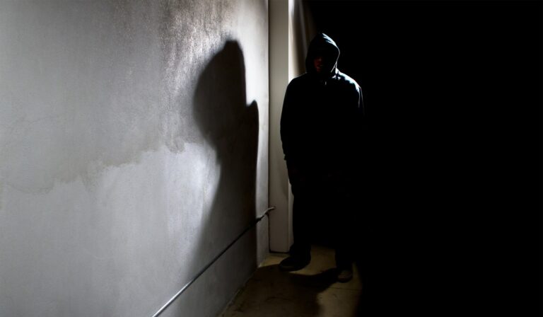 Personal standing in a dark alley which can be suspicious criminal behaviour